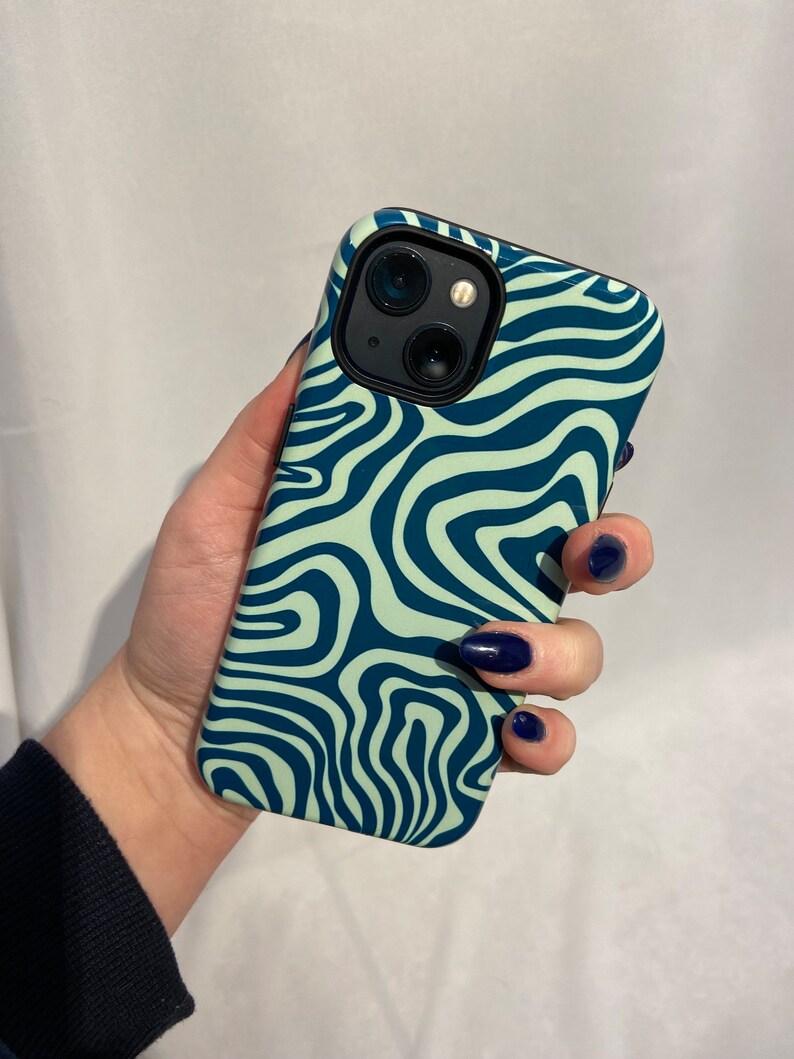 May include: A green and blue phone case with a wavy abstract pattern. The case has a black camera cutout.