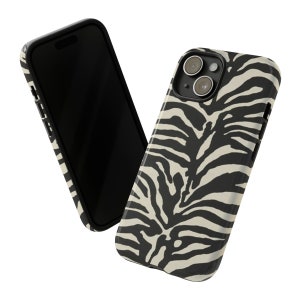 K&ouml;nnte beinhalten: Eine Handyh&uuml;lle mit Zebra-Muster in Schwarz und Wei&szlig; f&uuml;r ein iPhone. Die H&uuml;lle hat eine erh&ouml;hte Kamerabuckel und einen schwarzen Rand.