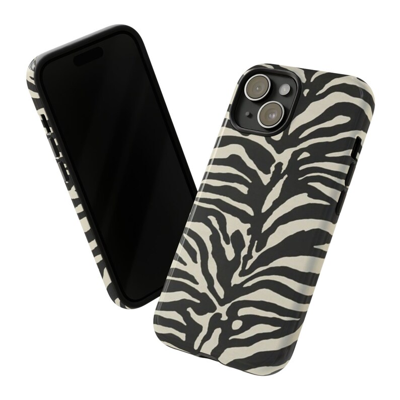 K&ouml;nnte beinhalten: Eine Handyh&uuml;lle mit Zebra-Muster in Schwarz und Wei&szlig; f&uuml;r ein iPhone. Die H&uuml;lle hat eine erh&ouml;hte Kamerabuckel und einen schwarzen Rand.