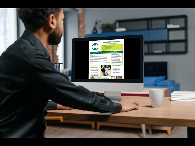 A man editing the capability statement template in Canva on his desktop computer.