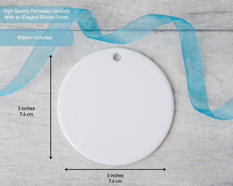 May include: A round white porcelain ceramic ornament with a glossy finish and a small hole at the top for hanging. The ornament measures 3 inches in height and 3 inches in width. A blue ribbon is included with the ornament for display purposes.
