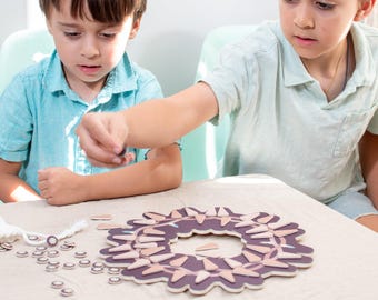 May include: Two children play a game with a wooden circular game board with a brown and beige design. The game board has a ring of small, triangular pieces that can be removed and placed in the center circle. The children are sitting at a table with a light brown tablecloth.