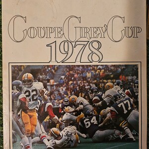 Peut inclure: Un programme vintage pour la Coupe Grey de 1978, avec une photo d'un match de football en cours. La couverture du programme est beige avec du texte noir qui dit "COUPE GREY CUP 1978". La photo montre un groupe de joueurs de football en action, avec un joueur au sol et d'autres autour de lui. Le texte au bas du programme dit "CNE STADIUM TORONTO SUNDAY, NOVEMBER 26/DIMANCHE LE 26 NOVEMBRE $2.00".