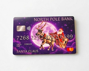 May include: A rectangular North Pole Bank card featuring a purple starry sky background with a large moon. The design shows Santa Claus in a sleigh pulled by a reindeer. Text includes NORTH POLE BANK, 7268 2252 8722 6599, UNTIL FOREVER, and SANTA CLAUS.