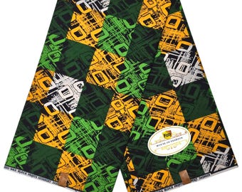 May include: A folded fabric with a geometric pattern in green, yellow, black, and white. The design features squares and lines. The fabric has a label that reads "Pizzy House of Fashion".
