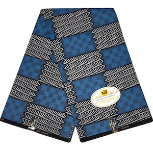 Puede incluir: Una tela azul doblada con un patrón geométrico de zigzags y cuadrados negros y blancos. La tela tiene una etiqueta que dice "Pizzy House of Fashion". La tela es de color azul vibrante.