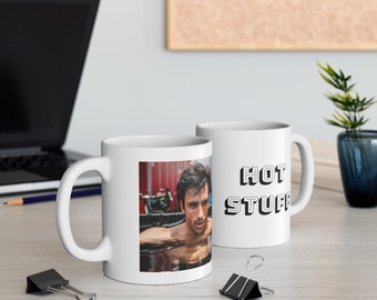 May include: Two white ceramic mugs. One mug features a photo of a man in a pool with the text "HOT STUFF" on the other mug.