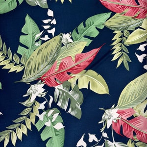 May include: A navy blue fabric with a tropical leaf pattern. The leaves are green, yellow, and red.