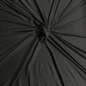 May include: Black ribbed fabric with a textured surface. The fabric is folded and gathered in the center.