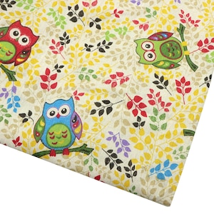 May include: A piece of fabric featuring a repeating pattern of owls in red, green, and blue perched on branches. The background is a light cream color decorated with a dense print of small yellow, green, black, red, and blue leaves on thin stems.