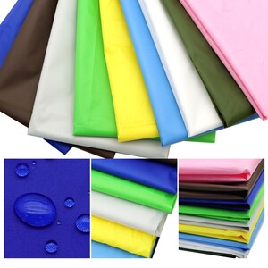 May include: A collection of colorful, folded fabric samples in various shades, including brown, white, green, yellow, blue, and pink. The fabric appears to be waterproof, with water droplets visible on a blue swatch. Ideal for craft projects.