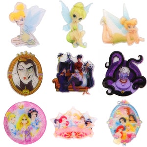 May include: Nine colourful, glittery, round, plastic Disney character stickers. The stickers feature Tinkerbell, Maleficent, Ursula, and the Disney princesses.
