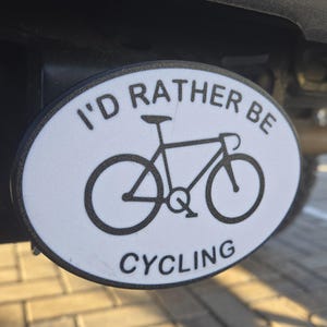 May include: White oval sticker with black text that reads "I'd rather be cycling". A black silhouette of a bicycle is in the centre of the sticker.