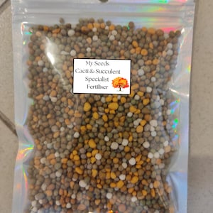 May include: A clear plastic bag filled with small, round, multi-coloured fertiliser pellets. The bag has a label that reads "My Seeds Cacti & Succulent Specialist Fertiliser".