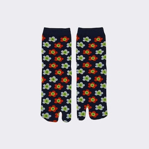 May include: A pair of blue tabi socks with a white and red floral pattern. The socks have a split toe design.