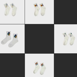 May include: A set of ten white ankle socks with colorful abstract designs. The socks are arranged in three rows of two socks each.