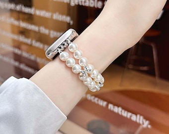 May include: A white pearl watch band with a silver clasp. The band features two strands of round, white pearls, connected by silver accents. The watch band is designed to fit a smartwatch.