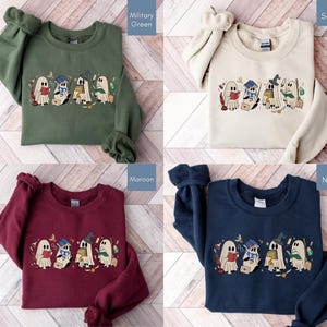 Halloween sweatshirt featuring a cute reading ghosts dressed as wizard houses, perfect for spooky season. This wizard shirt doubles as a fun wizarding school tee or Halloween tee, ideal for Halloween matching, family trips, or Halloween group outfits with a magical twist.