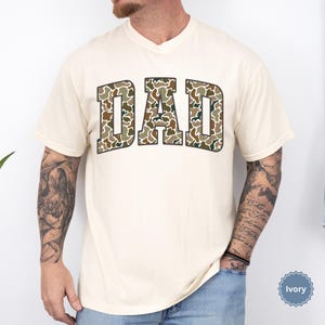 Cool and rugged Camo Dad Shirt designed for the ultimate Hunting Dad—perfect as a New Dad Father's Day Gift or Dad Birthday Gift. This comfortable and stylish Camouflage Dad Shirt makes a great Gift for Dad who loves the outdoors. A must-have Dad Tee for everyday wear, this Dad Tshirt is a top pick for any proud papa. Whether you're shopping for a Dad Gift or the Best Dad Gift, this shirt delivers both style and sentiment.