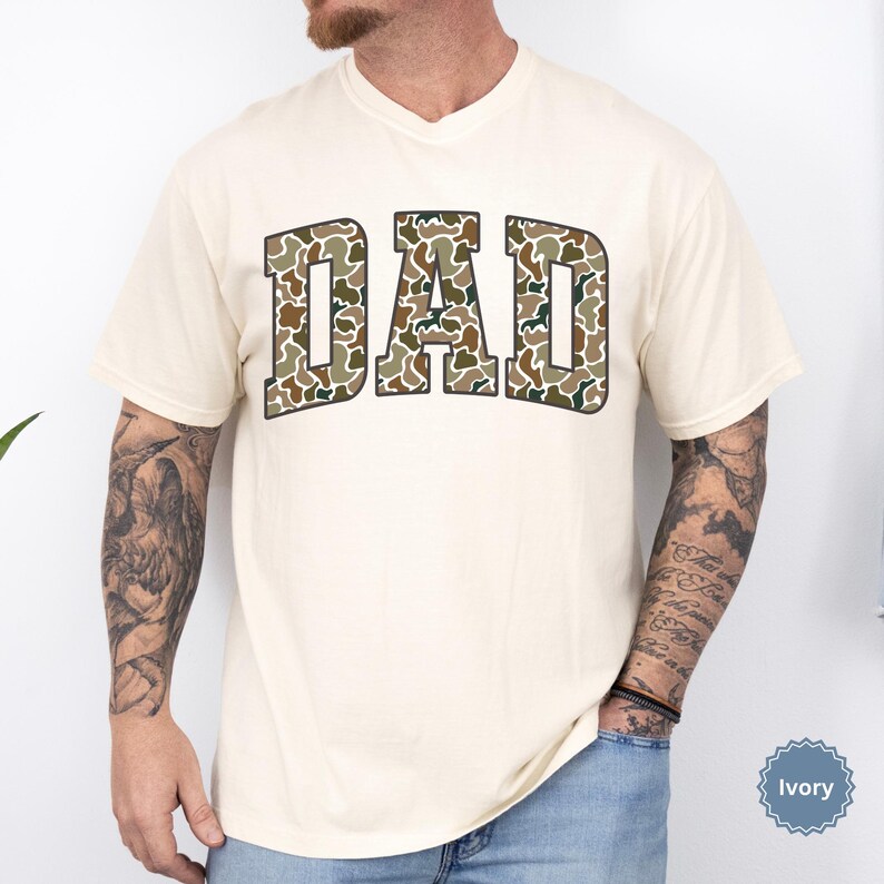 Cool and rugged Camo Dad Shirt designed for the ultimate Hunting Dad—perfect as a New Dad Father's Day Gift or Dad Birthday Gift. This comfortable and stylish Camouflage Dad Shirt makes a great Gift for Dad who loves the outdoors. A must-have Dad Tee for everyday wear, this Dad Tshirt is a top pick for any proud papa. Whether you're shopping for a Dad Gift or the Best Dad Gift, this shirt delivers both style and sentiment.