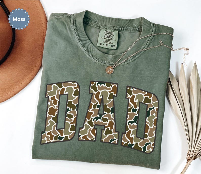 Cool and rugged Camo Dad Shirt designed for the ultimate Hunting Dad—perfect as a New Dad Father's Day Gift or Dad Birthday Gift. This comfortable and stylish Camouflage Dad Shirt makes a great Gift for Dad who loves the outdoors. A must-have Dad Tee for everyday wear, this Dad Tshirt is a top pick for any proud papa. Whether you're shopping for a Dad Gift or the Best Dad Gift, this shirt delivers both style and sentiment.