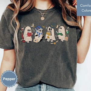 Halloween shirt featuring a cute reading ghosts dressed as wizard houses, perfect for spooky season. This wizard shirt doubles as a fun wizarding school tee or Halloween tee, ideal for Halloween matching, family trips, or Halloween group outfits with a magical twist.