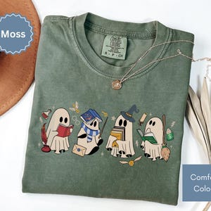 Halloween shirt featuring a cute reading ghosts dressed as wizard houses, perfect for spooky season. This wizard shirt doubles as a fun wizarding school tee or Halloween tee, ideal for Halloween matching, family trips, or Halloween group outfits with a magical twist.