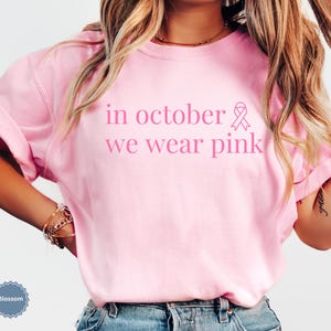 In October We Wear Pink in a simple lettering. This Halloween Tee is perfect for healthcare heroes or anyone supporting Breast Cancer Awareness during spooky season. A thoughtful and festive Oncology Nurse Tee or Cute Nurse Tshirt for October events, hospital shifts, or awareness walks. Celebrate with this Pink Ribbon Shirt designed for nurses or medical assistants who care.