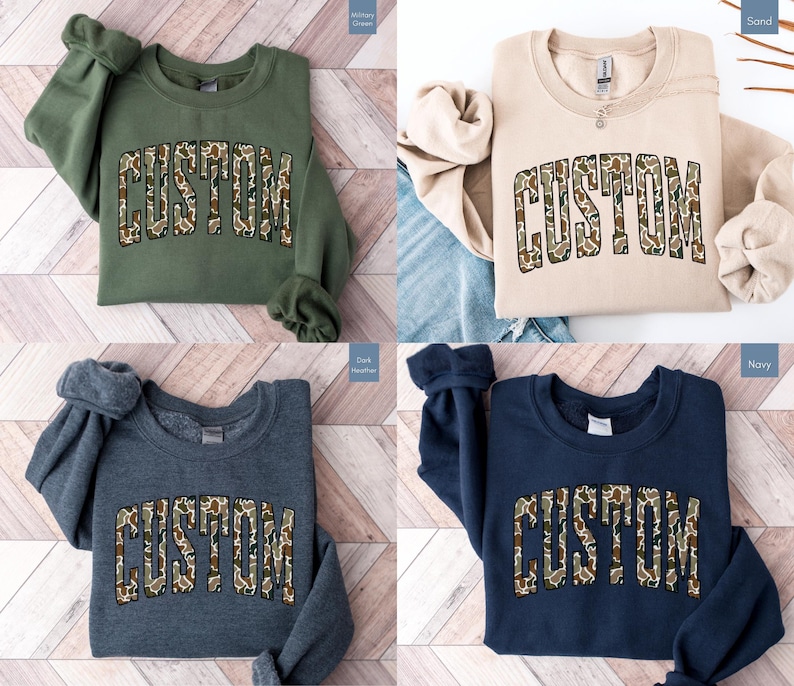 Custom Camo Shirt featuring bold varsity-style font — the perfect Camouflage Shirt for deer hunting, duck hunting, or casual wear during hunting season. This cozy Camo Sweatshirt makes a thoughtful Hunting Lover Gift, combining rugged outdoor style with personalized comfort.