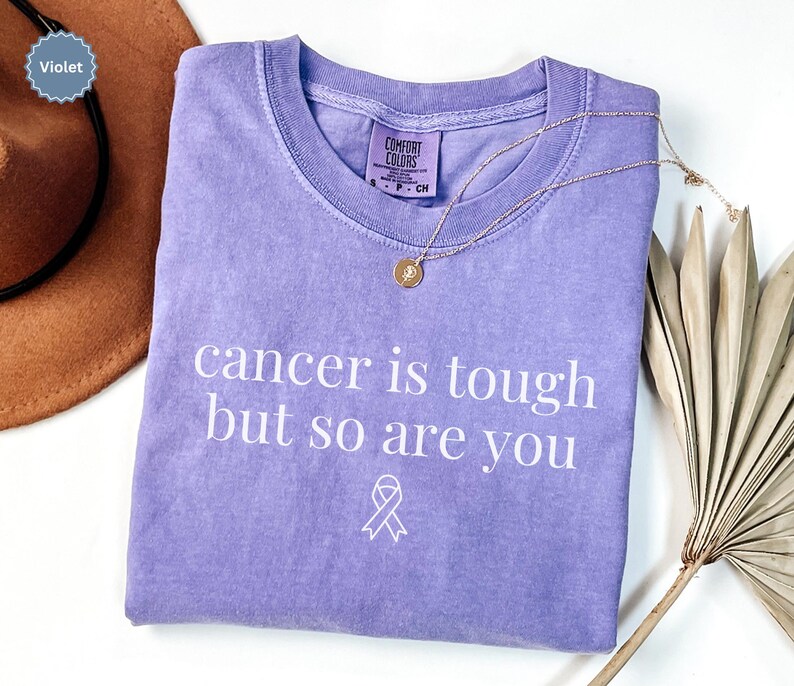 "Cancer is tough but so are you" in a simple text lettering. This Cancer awareness shirt is perfect for healthcare heroes or anyone supporting Breast Cancer Awareness, childhood cancer, cervical cancer and more. Makes a great oncology Nurse Tee or Nurse Tshirt for October events, hospital shifts, cancer encouragement shirt or cancer awareness walks. Show them their fight is out fight with this cancer Ribbon Shirt, not just for nurses or medical assistants.