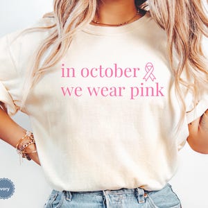 In October We Wear Pink in a simple lettering. This Halloween Tee is perfect for healthcare heroes or anyone supporting Breast Cancer Awareness during spooky season. A thoughtful and festive Oncology Nurse Tee or Cute Nurse Tshirt for October events, hospital shifts, or awareness walks. Celebrate with this Pink Ribbon Shirt designed for nurses or medical assistants who care.