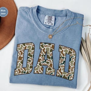 Cool and rugged Camo Dad Shirt designed for the ultimate Hunting Dad—perfect as a New Dad Father's Day Gift or Dad Birthday Gift. This comfortable and stylish Camouflage Dad Shirt makes a great Gift for Dad who loves the outdoors. A must-have Dad Tee for everyday wear, this Dad Tshirt is a top pick for any proud papa. Whether you're shopping for a Dad Gift or the Best Dad Gift, this shirt delivers both style and sentiment.