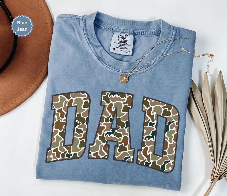 Cool and rugged Camo Dad Shirt designed for the ultimate Hunting Dad—perfect as a New Dad Father's Day Gift or Dad Birthday Gift. This comfortable and stylish Camouflage Dad Shirt makes a great Gift for Dad who loves the outdoors. A must-have Dad Tee for everyday wear, this Dad Tshirt is a top pick for any proud papa. Whether you're shopping for a Dad Gift or the Best Dad Gift, this shirt delivers both style and sentiment.