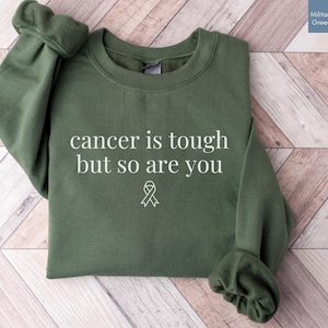 "Cancer is tough but so are you" in a simple text lettering. This Cancer awareness shirt is perfect for healthcare heroes or anyone supporting Breast Cancer Awareness, childhood cancer, cervical cancer and more. Makes a great oncology Nurse Tee or Nurse Tshirt for October events, hospital shifts, cancer encouragement shirt or cancer awareness walks. Show them their fight is out fight with this cancer Ribbon Shirt, not just for nurses or medical assistants.