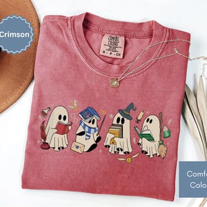 Halloween shirt featuring a cute reading ghosts dressed as wizard houses, perfect for spooky season. This wizard shirt doubles as a fun wizarding school tee or Halloween tee, ideal for Halloween matching, family trips, or Halloween group outfits with a magical twist.
