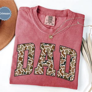 Cool and rugged Camo Dad Shirt designed for the ultimate Hunting Dad—perfect as a New Dad Father's Day Gift or Dad Birthday Gift. This comfortable and stylish Camouflage Dad Shirt makes a great Gift for Dad who loves the outdoors. A must-have Dad Tee for everyday wear, this Dad Tshirt is a top pick for any proud papa. Whether you're shopping for a Dad Gift or the Best Dad Gift, this shirt delivers both style and sentiment.