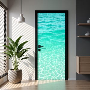 Puede incluir: Una puerta rectangular con una impresión de alta resolución de agua de mar turquesa clara con ondas de luz visibles y patrones de arena en el fondo. La puerta tiene un marco negro y un tirador horizontal negro con una cerradura a juego.