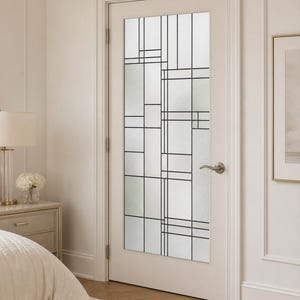 Puede incluir: Una puerta interior blanca con un gran panel de vidrio rectangular que presenta un patrón geométrico de finas líneas negras. El vidrio tiene un acabado esmerilado y texturizado. Una manija de palanca de níquel cepillado está instalada.