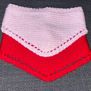 May include: A two-layered crochet bandana featuring a light pink top layer and a vibrant red bottom layer. Both pieces are crafted with a dense stitch pattern and finished with a decorative openwork border along the bottom edge of each section.