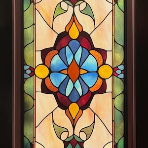Puede incluir: Una ventana rectangular de vidrieras con un marco de madera marrón oscuro. El diseño presenta un motivo floral central en tonos de azul, naranja y rojo, rodeado de patrones simétricos en verde, amarillo y crema. El vidrio está dividido por líneas negras.