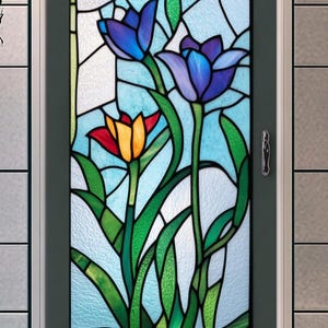 Puede incluir: Un panel de vitral con un diseño floral colorido con tres tulipes en tonos de azul, rojo y amarillo. Las tulipes están rodeadas de hojas verdes y sobre un fondo azul claro.