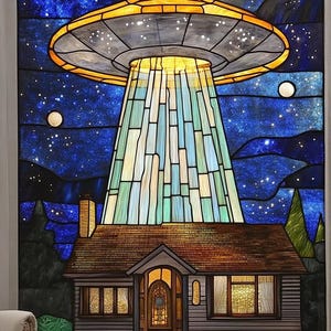 Puede incluir: Una ventana de vitral que representa un OVNI flotando sobre una pequeña casa con una ventana iluminada. El cielo nocturno está lleno de estrellas y tres lunas.