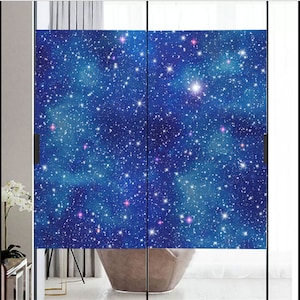May include: A pair of glass doors with a blue and white galaxy-themed window film. The film features a dark blue background with white stars and a few pink stars.