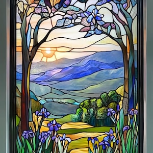 Op de afbeelding: Een gebrandschilderd raam met een landschapsscène met een zonsondergang over bergen, bomen en bloemen. De kleuren zijn levendig en omvatten blauw, groen, geel en paars.