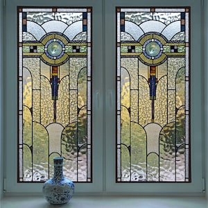 May include: A pair of stained glass windows with a geometric design featuring arches, circles, and squares in shades of blue, green, yellow, and brown.