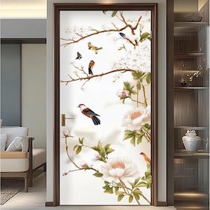 Puede incluir: Una calcomanía de puerta blanca con un diseño floral que presenta flores blancas, hojas verdes y pájaros marrones. Los pájaros están posados en las ramas de las flores.