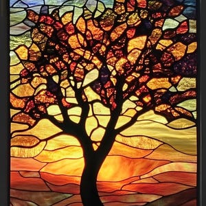Puede incluir: Una ventana de vitral que representa la silueta de un árbol con un tronco y ramas de color marrón oscuro sobre un fondo de puesta de sol. La puesta de sol es una mezcla vibrante de tonos naranja, amarillo y rojo, con un cielo azul arriba. Las piezas de vidrio están dispuestas en un patrón de mosaico, creando un diseño texturizado e intrincado.
