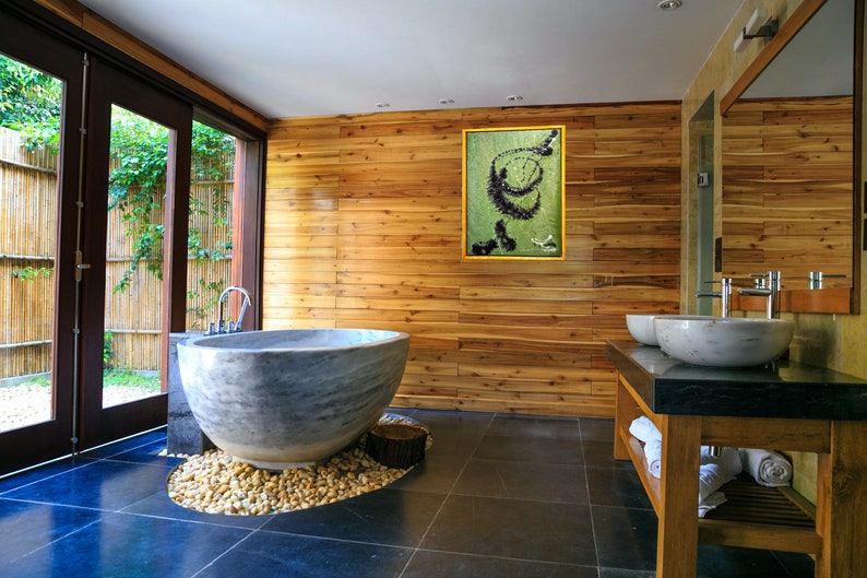 Pu&ograve; includere: Un bagno con una grande vasca da bagno rotonda in pietra grigia, un mobile in legno con due lavabi in porcellana bianca e un dipinto astratto incorniciato sulla parete.
