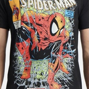 May include: Black t-shirt with a Spider-Man comic book cover design. The graphic shows Spider-Man in a dynamic pose, with web-like lines. The shirt also features the Marvel Comics logo and the text "TORMENT PART ONE OF FIVE."