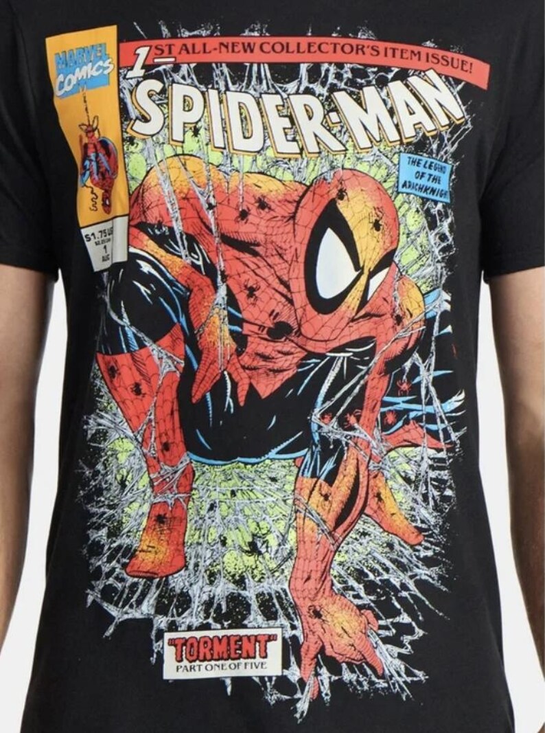 May include: Black t-shirt with a Spider-Man comic book cover design. The graphic shows Spider-Man in a dynamic pose, with web-like lines. The shirt also features the Marvel Comics logo and the text "TORMENT PART ONE OF FIVE."